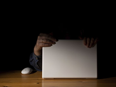 holding a laptop in the dark