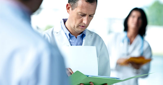 Five Steps to Optimal HIPAA Compliance - Doctor looking at files