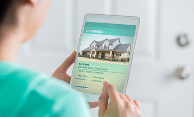  Navigating the Digital Mortgage Revolution - A woman using her phone to search a new house