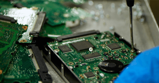 Recycle or Remarket Your Data Center Equipment With Iron Mountain’s SITAD Solution -Man Working on Motherboard  | Iron Mountain