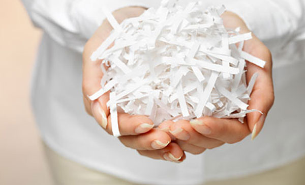 Is Your RIM Policy Incomplete? Add Secure Shredding Services- A person holding shredded paper